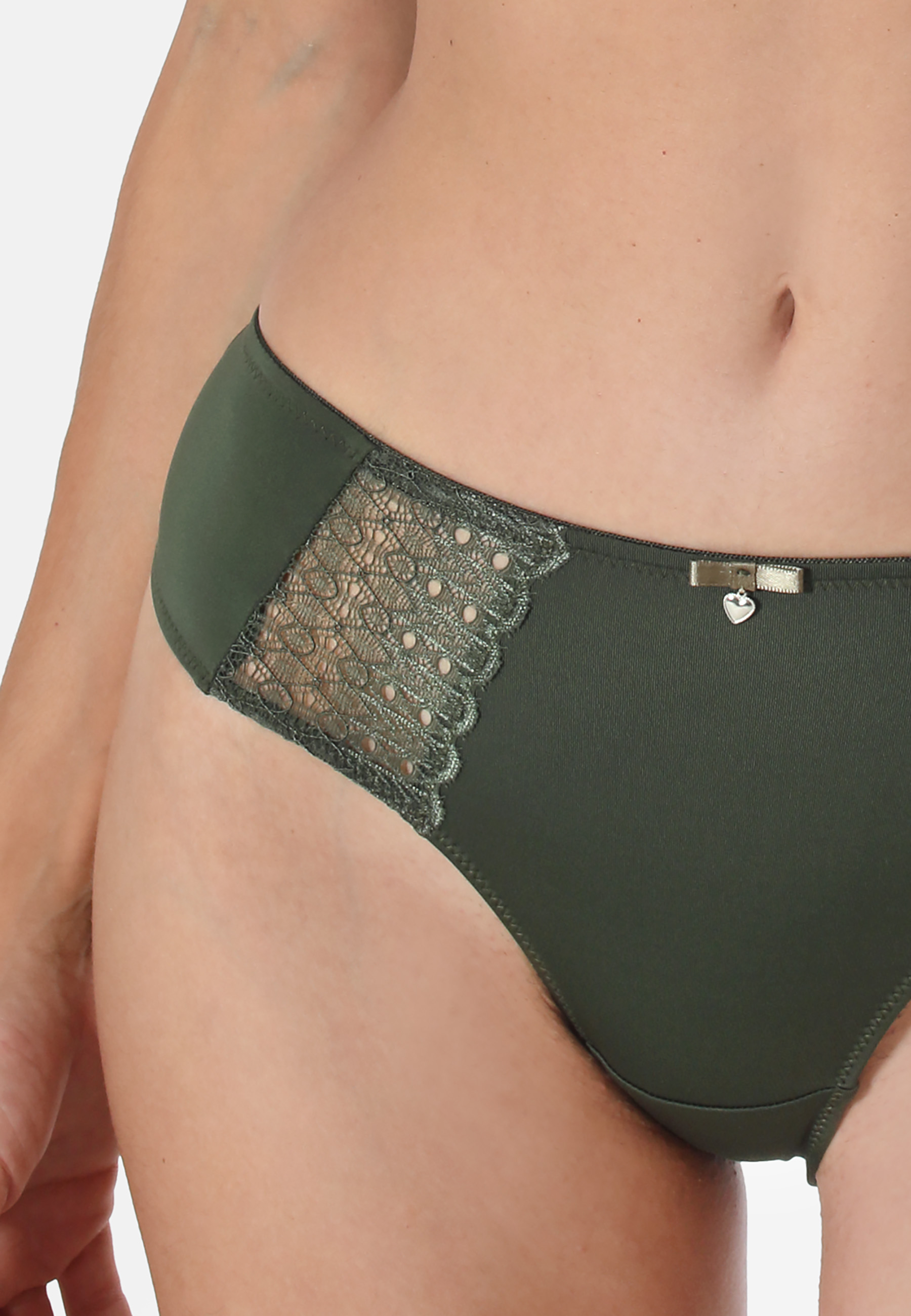 Schöner Slip mit seitlichen Spitzeneinsätzen. Vorder- und Rückteil sind aus glänzender Microfaser. Sehr angenehm zu tragen.SlipGlänzende MicrofaserSpitzeneinsätze im VorderteilFarblich abgestimmte Zierschleife aus Satin mit silberfarbenem Herzchen-Accesso